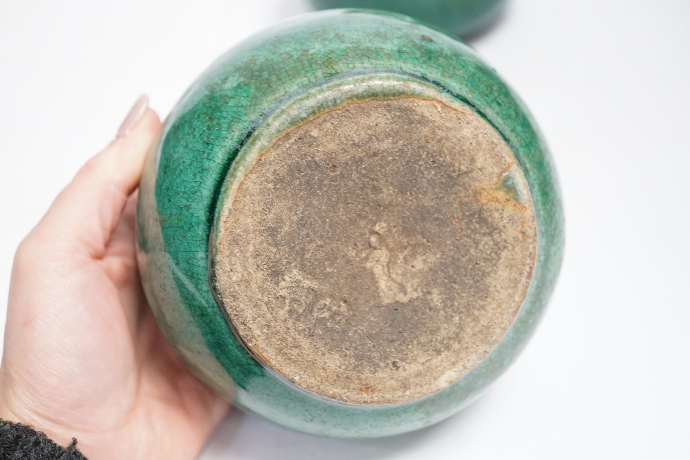 A pair of Chinese pottery monochrome green glazed jars, 10cm high